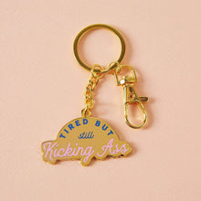 Load image into Gallery viewer, Tired But Kicking Ass Enamel Keyring
